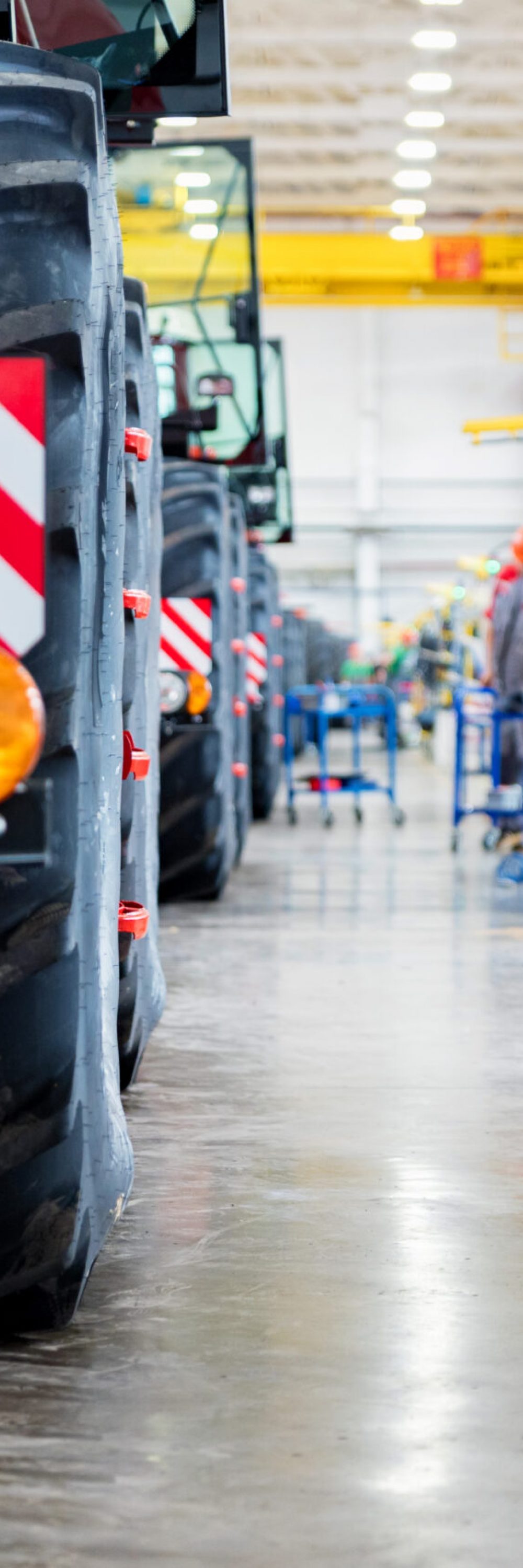 Defocused image of assembly room at big industrial plant manufacturing tractors and harvesters