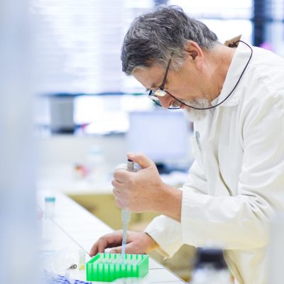 senior male researcher carrying out scientific research in a lab (shallow DOF; color toned image)